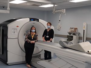 health-care professionals standing next to PET scan equipment