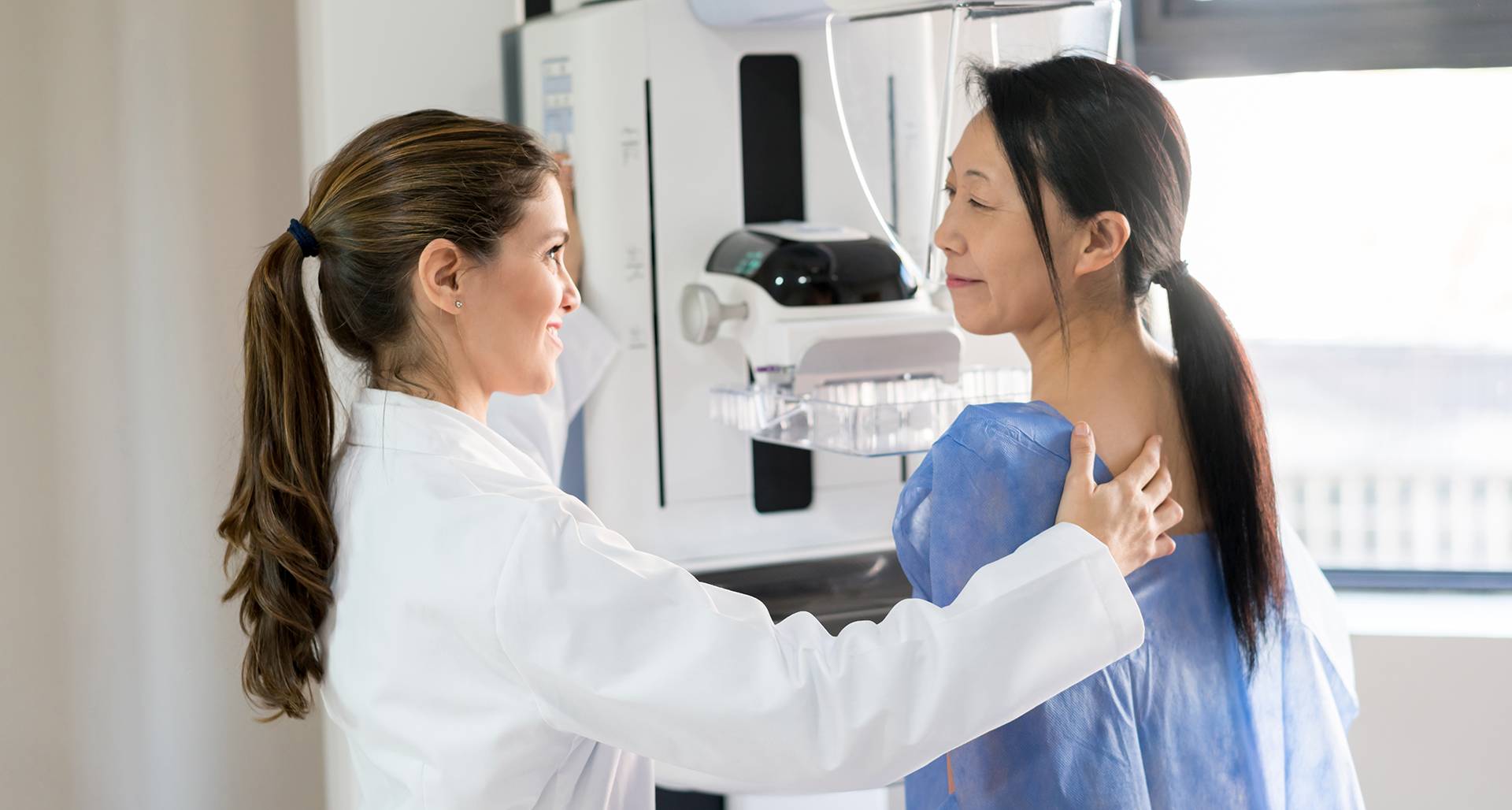 health-care professional guiding woman through medical imaging procedure